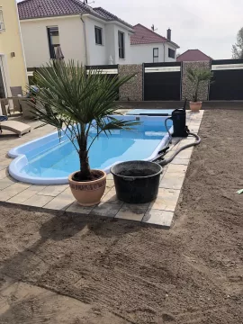 Natursteinterrasse mit eingelassenem Pool auf Betonfundament